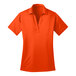 A Port Authority neon orange silk touch polo shirt with a collar and short sleeves.