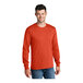 A man wearing an orange Port & Company long sleeve t-shirt.
