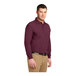 A man wearing a Port Authority burgundy long sleeve polo.