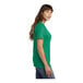 A woman wearing a green Port & Company v-neck t-shirt.