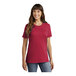 A woman wearing a red Port & Company t-shirt.