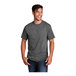 A man smiling and wearing a graphite heather Port & Company short sleeve t-shirt.