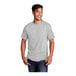 A man smiling and wearing an extra large Port & Company short sleeve t-shirt in ash grey.