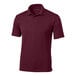 A white background with a maroon Sport-Tek short sleeve polo shirt with a collar.