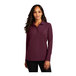 A woman wearing a Port Authority burgundy long sleeve polo shirt.