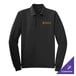 A black Port Authority long sleeve polo shirt on a counter with gold embroidery.