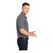 A man wearing a gray Sport-Tek moisture-wicking polo.