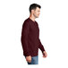 A man wearing a maroon Port & Company long sleeve t-shirt.