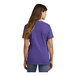 A woman wearing a purple Port & Company short sleeve T-shirt.