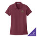 A medium women's maroon Port Authority polo shirt with a green logo.