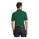 A man wearing a deep forest green Port Authority polo shirt.