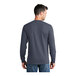 A man wearing a Port & Company heather navy long sleeve T-shirt.