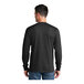 A man wearing a Port & Company black long sleeve shirt.