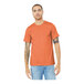 A man wearing a Bella + Canvas heather orange short sleeve t-shirt.