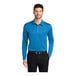 A man wearing a Port Authority Brilliant Blue long sleeve polo shirt.