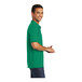 A man wearing a green Port & Company short sleeve polo shirt.