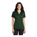 A woman wearing a dark green Port Authority silk touch polo shirt.