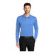 A man wearing a Port Authority Carolina blue long sleeve polo shirt.