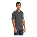 A man wearing a Port & Company charcoal short sleeve jersey knit polo shirt.