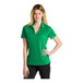 A woman wearing a green Nike polo shirt.