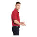 A man wearing a Sport-Tek red polo shirt.