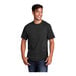 A man smiling and wearing a jet black Port & Company short sleeve t-shirt.