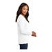 A woman wearing a white Port & Company long sleeve t-shirt.