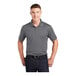 A man wearing a Sport-Tek gray concrete short sleeve polo shirt.