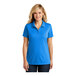 A woman wearing a Port Authority women's blue short sleeve polo shirt.