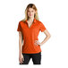 A woman wearing a brilliant orange Nike polo shirt.