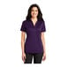 A woman wearing a Port Authority bright purple short sleeve polo shirt.