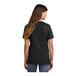 A woman wearing a black Port & Company short sleeve t-shirt.