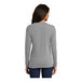 A woman wearing a Port & Company athletic heather long sleeve shirt.