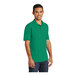 A man wearing a Kelly green Port & Company polo shirt.