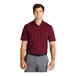 A man wearing a burgundy Nike Dri-Fit polo shirt.