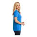 A woman wearing a Port Authority Dry Zone True Royal short sleeve polo shirt.