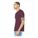 A man wearing a heather maroon Bella + Canvas t-shirt and jeans.