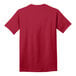 A close-up of a red Port & Company short sleeve t-shirt with a white logo on the front.