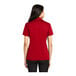 A woman wearing a red Port Authority silk touch polo shirt.