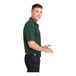 A man wearing a forest green Sport-Tek short sleeve polo shirt.