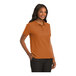A woman wearing a Texas orange Port Authority polo shirt.