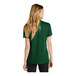 A woman wearing a Nike green short sleeve polo shirt.