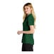 A woman wearing a Nike Gorge Green polo shirt.