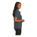 A woman wearing a steel gray Port Authority polo shirt.