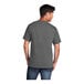 A man wearing a Port & Company charcoal short sleeve t-shirt.