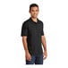 A man wearing a black Port & Company jersey knit polo shirt.