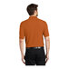 A man wearing a Texas orange Port Authority® polo shirt.