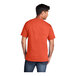 A man wearing a Port & Company orange short sleeve t-shirt.