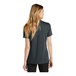 A woman wearing a Nike anthracite short sleeve polo shirt.