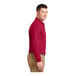 A man wearing a red Port Authority® long sleeve polo shirt.